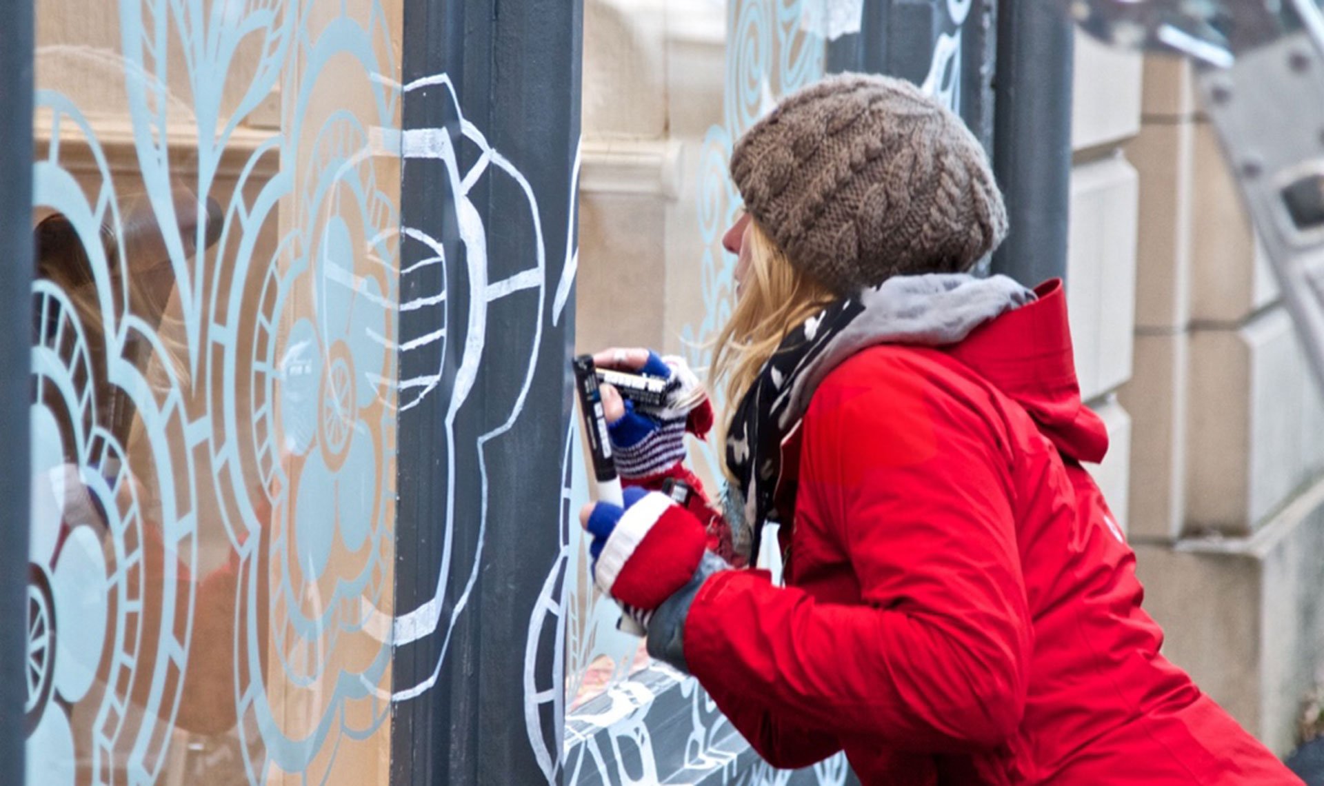 Kate George painting Bindi artwork on window