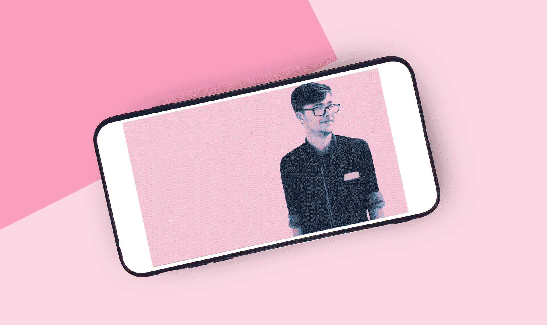 image on smartphone of young man wearing glasses set to a pink background